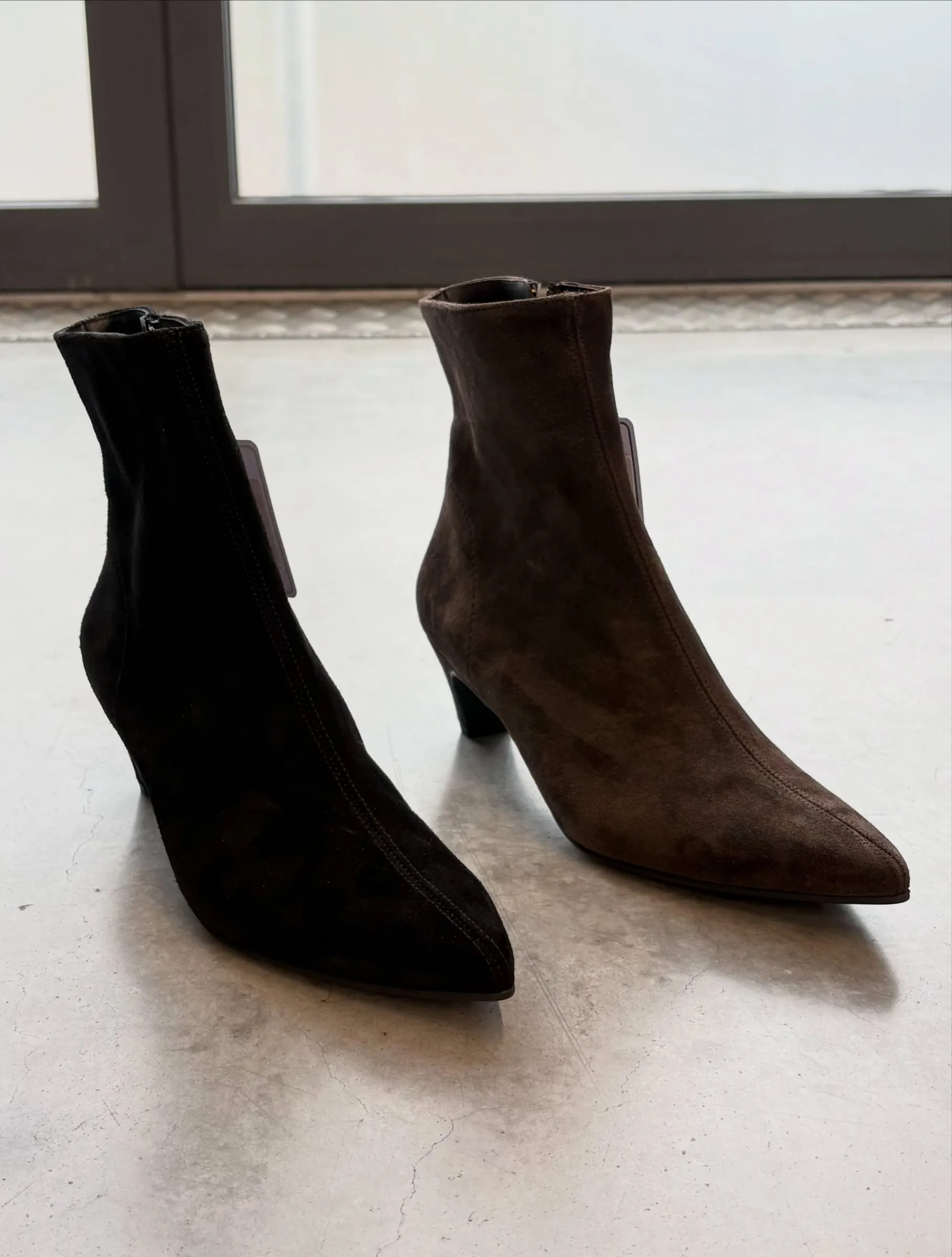 Schwarze und braune Damenstiefeletten im Schaufensterlicht
