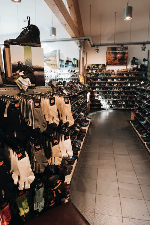 Funktionssocken und Outdoor-Zubehör neben dem Schuhsortiment