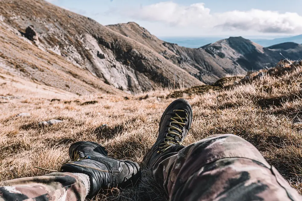 Wanderschuhe an den Füßen mit Blick auf eine Berglandschaft